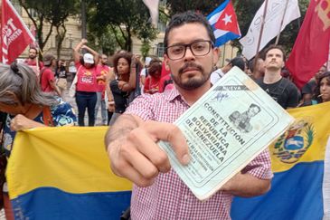 Gilberto Costa/Agência Brasil Rio de Janeiro (RJ), 05/01/2026 - Ali Alvarez, de 31 anos - Manifestante mostra constituição da Venezuela durante ato na Cinelândia contra a invasão dos Estados Unidos na Venezuela. Foto: Gilberto Costa/Agência Brasil