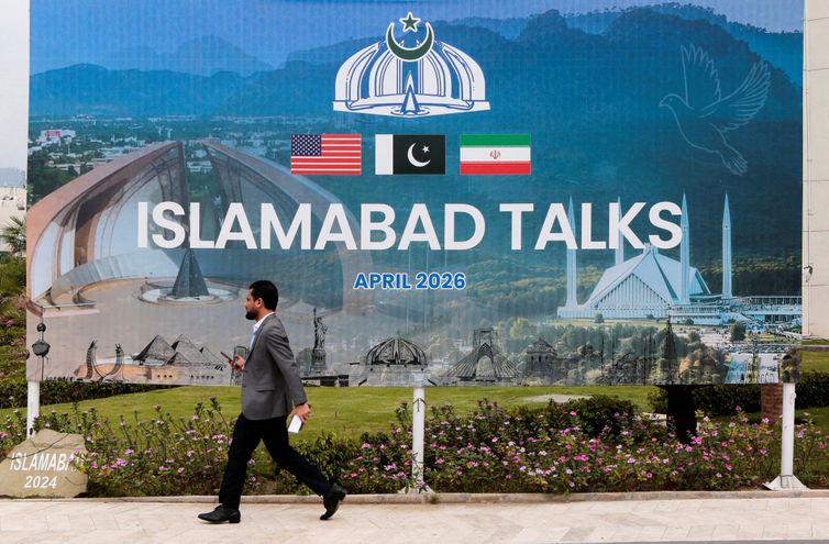 A man walks past a billboard near the media centre as delegations from the United States and Iran are expected to hold peace talks in Islamabad, Pakistan, April 11, 2026. REUTERS/Asim Hafeez     TPX IMAGES OF THE DAY        REFILE - CHANGING FROM 