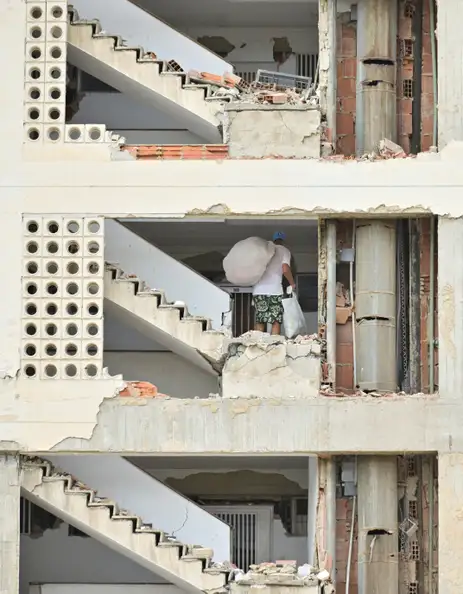 A man carrying belongings walks in a damaged building, after earthquakes hit the country, in La Guaira, Venezuela, June 28, 2026. REUTERS/Maxwell Briceno     TPX IMAGES OF THE DAY